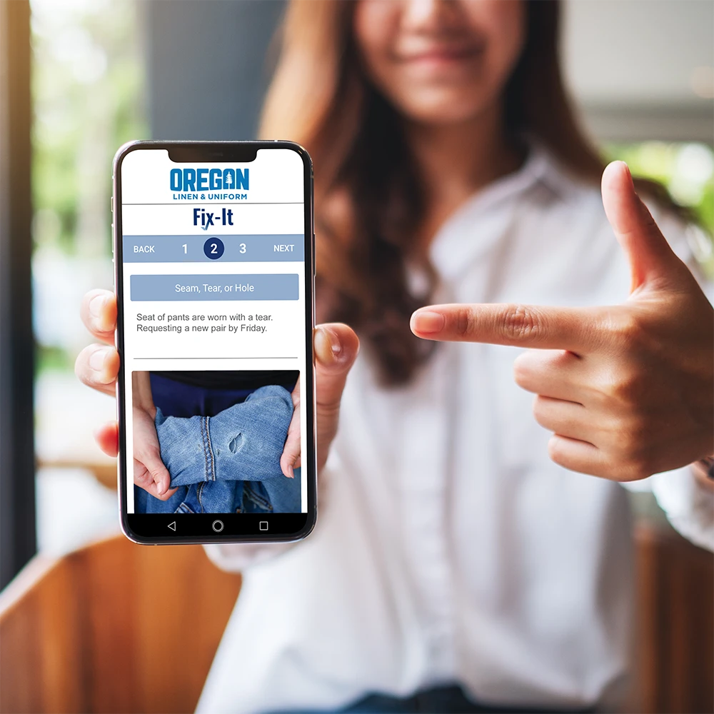 Fix-It_Image1 Oregon Linen & Uniform Fix it App Shown on Phone