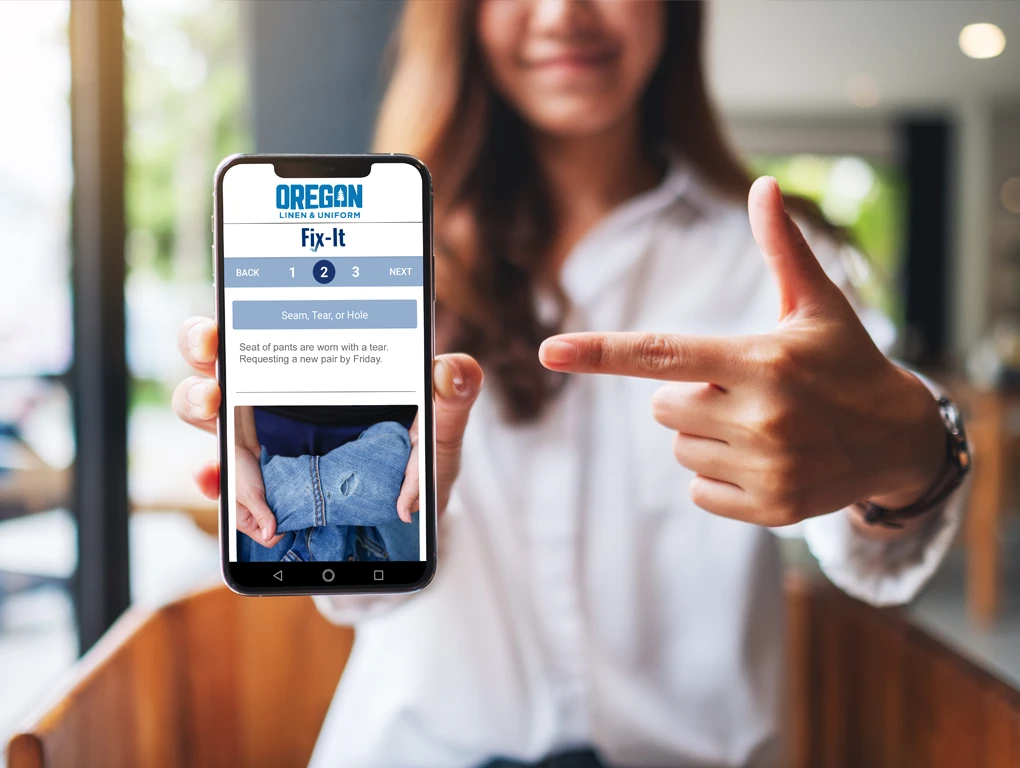 Oregon Linen & Uniform Fix it App Shown on Phone