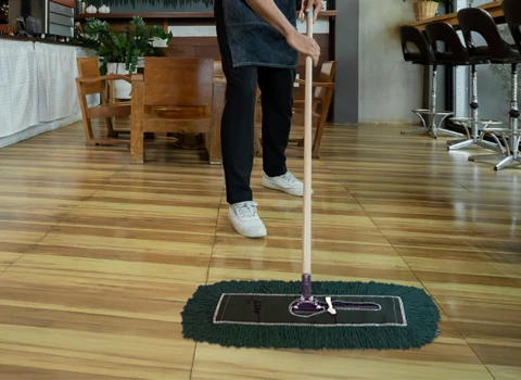 Commercial Mop Rental Service - Dust Mop being used to clean the floor of a coffee shop
